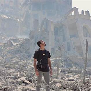 Le jeune journaliste devant les décombres de son quartier